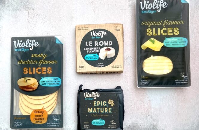 a photo of a packet of Violife smoky cheddar flavour slices, Violife Le Rond Camembert flavour, Violife Epic Mature and Violife original flavour slices